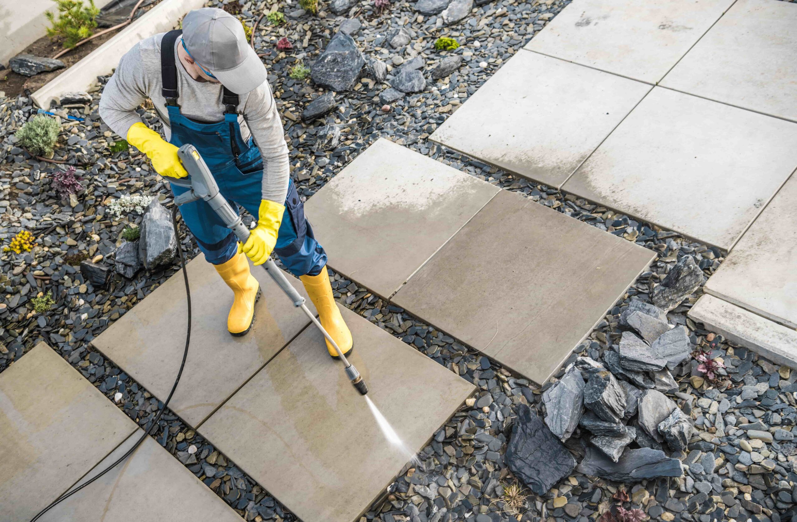 homeowner-washing-out-dirt-from-his-garden-concret-2023-11-27-05-15-14-utc